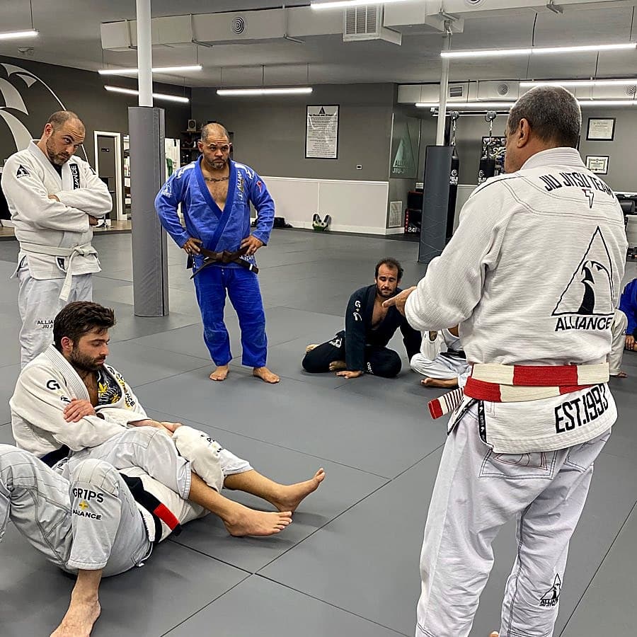 Master Carlos Rollyson in his coral belt teaching an adult class at Rollyson BJJ